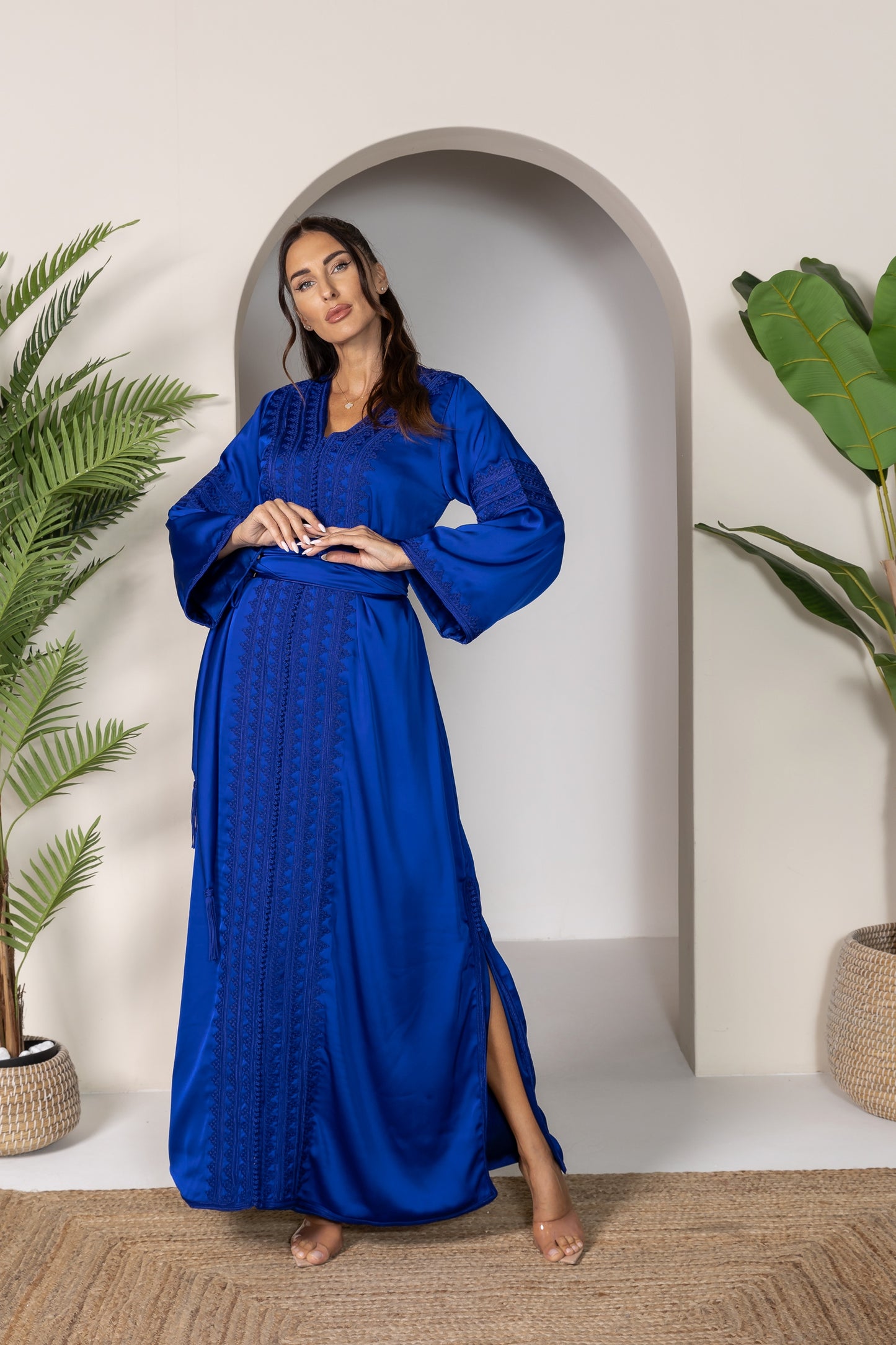 Woman in blue Moroccan kaftan with wide sleeves and a matching belt